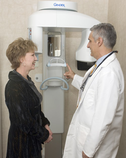 Dr. Rossetti showing a patient how their x-ray machine works