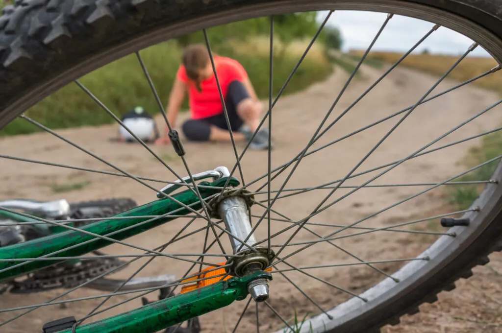 Young woman with tooth pain after falling down from bicycle will need an emergency dentist appointment very quickly.